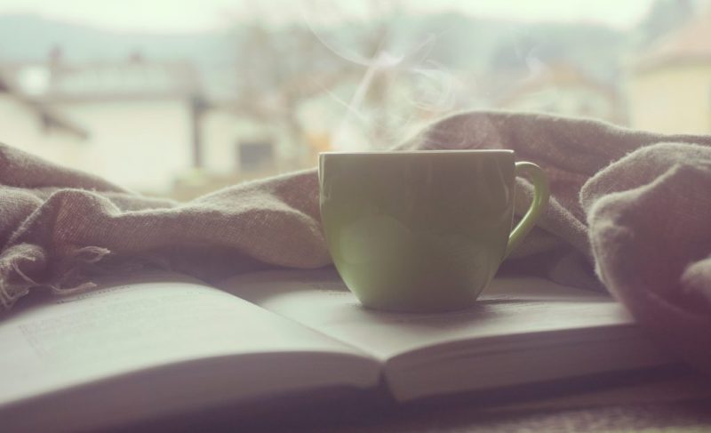 A steaming cup on top of a book