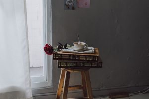 A tea-filled cup on a stack of books placed on a stool