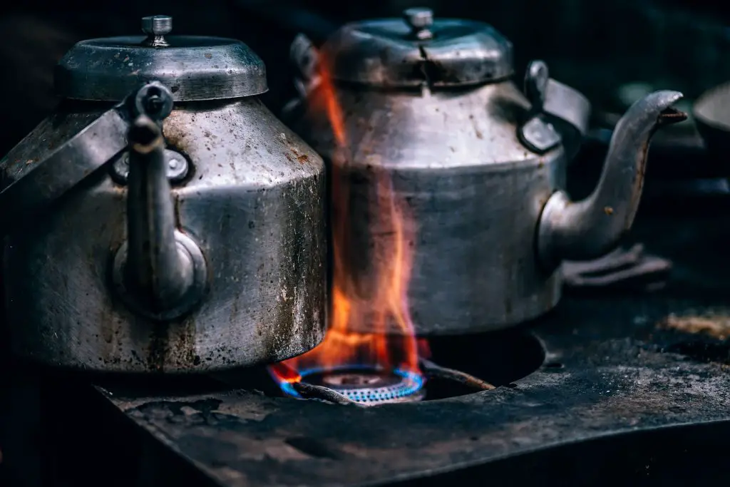 Tea kettles on a stove with a strong fire