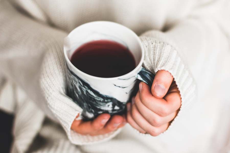 Person holding a cup filled with tea good for inflammation