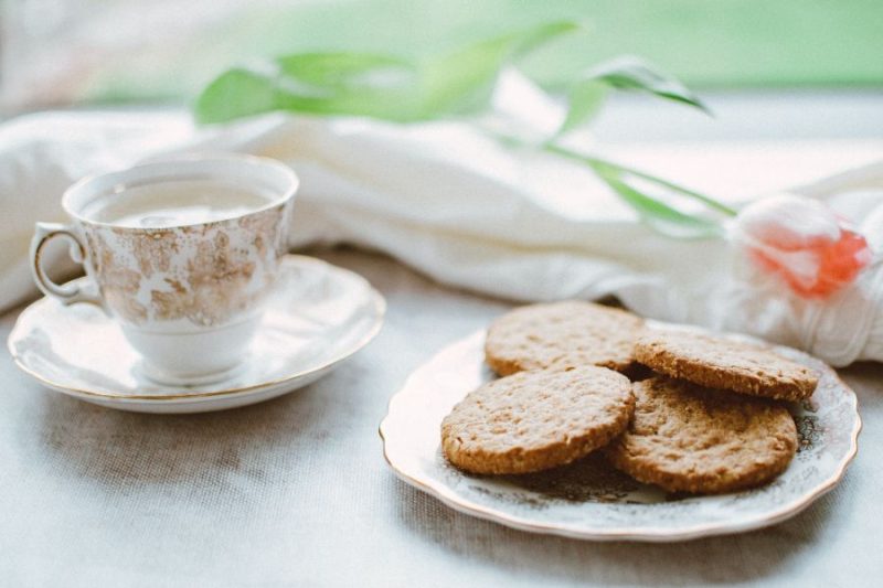 A cup of English breakfast tea beside a plate of cookies